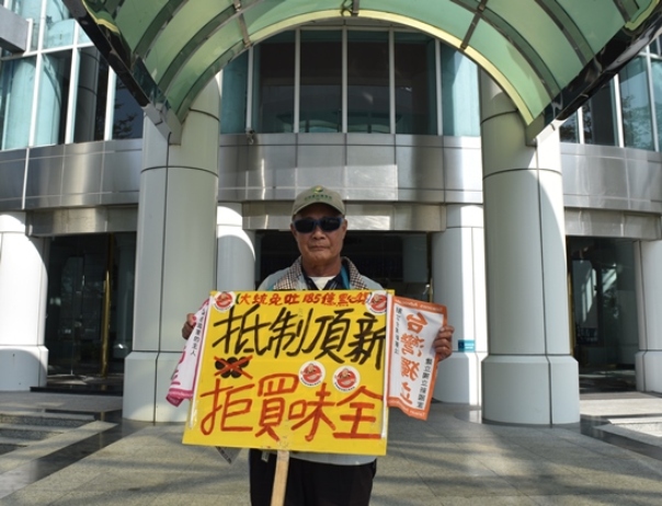 不滿頂新劣油案以罪證不足宣判無罪，台南市民獨自在議會門口舉牌抗議。（記者陳祺昌攝）