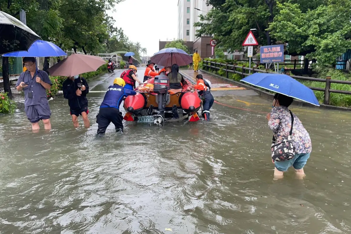 台南豪雨成災,消防局調派橡皮艇協助就醫民眾穿越淹水路段。
